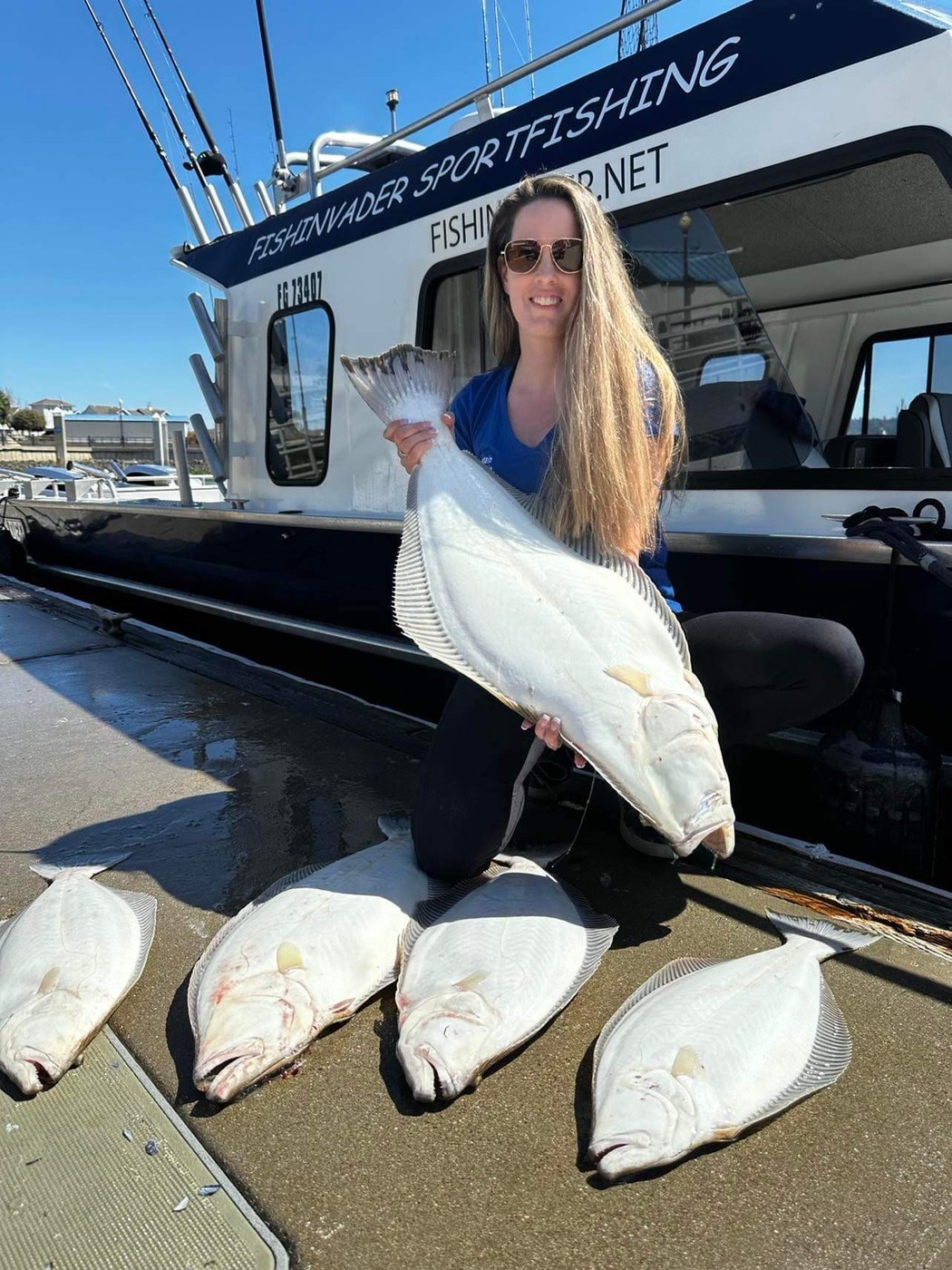 Captain Stephanie with a halibut alongside the Fish Invader