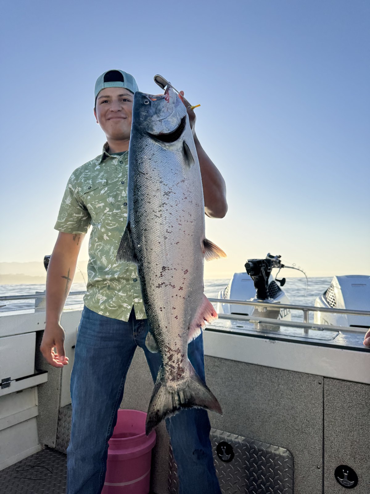 A young angler holding a king salmon