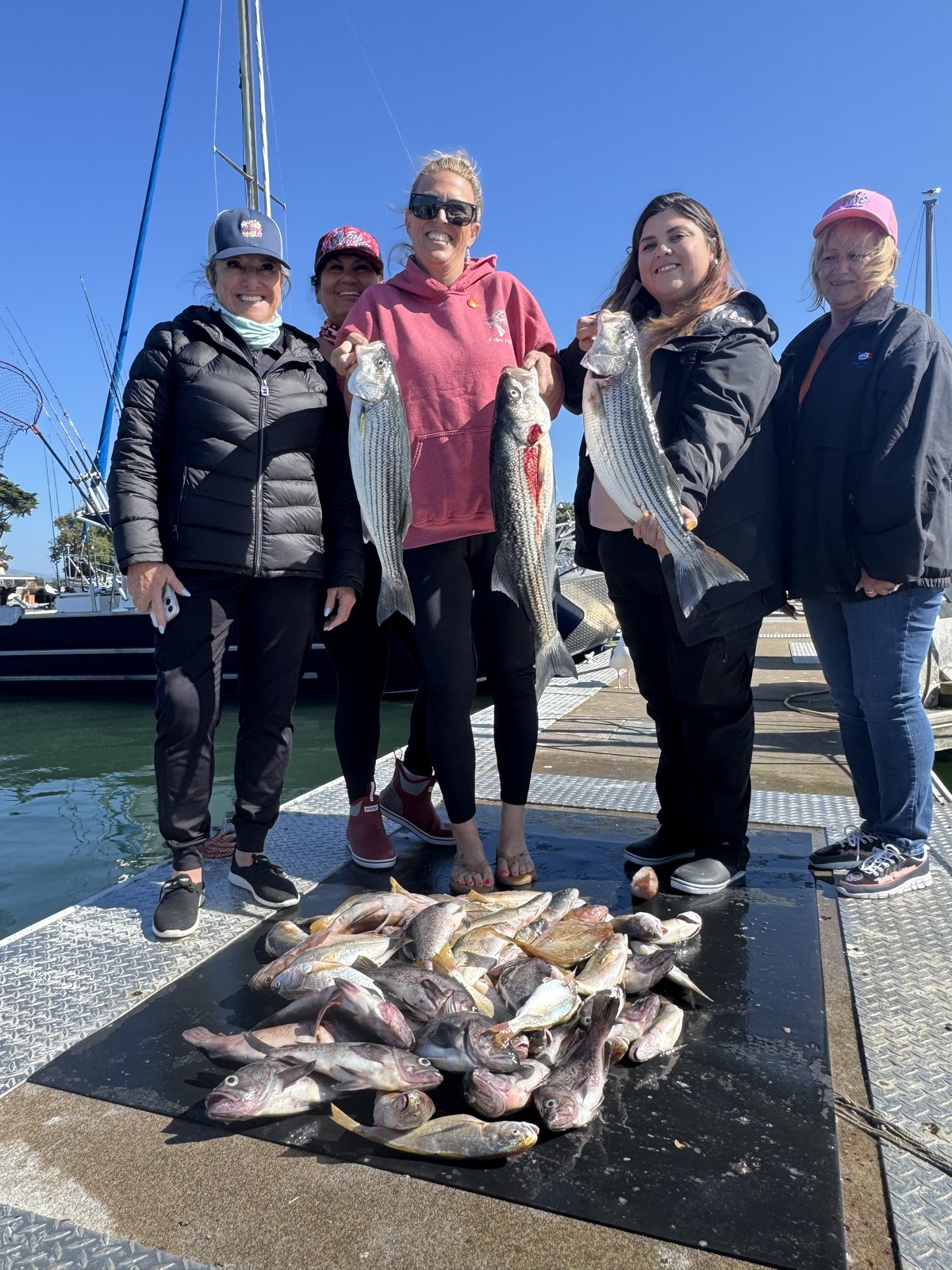 A group of women on the dock with their rockfish catch