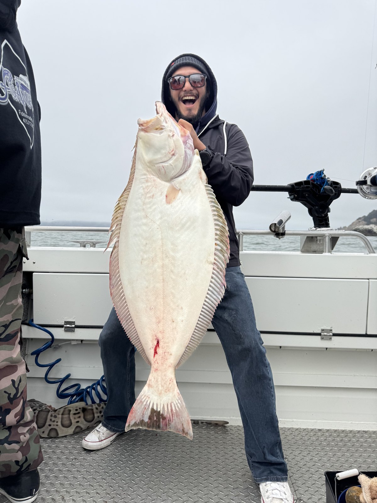 A happy angler holding up a big halibut